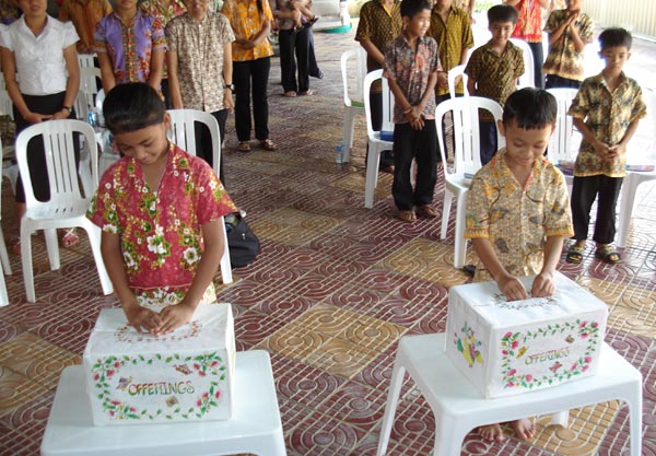 A photo children bringing offerings